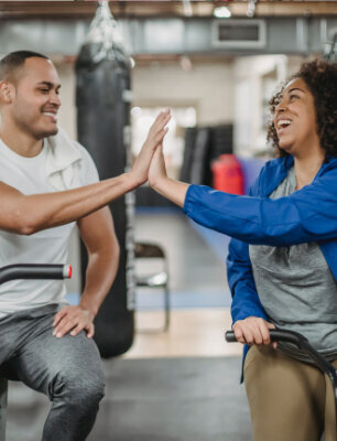 a man and a woman high five after a workout and show accessible fitness