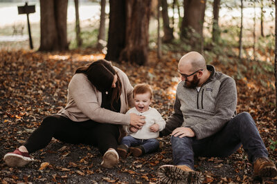 family sitting in the leaves laughing