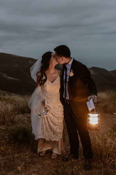 bride and groom kissing with lantern