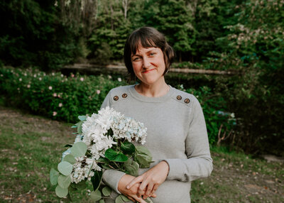 Erin, therapist at First Star, holding a bouquet of flowers and smiles