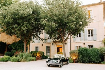 Black classic car parked in front of a romantic French country estate wedding venue in Provence
