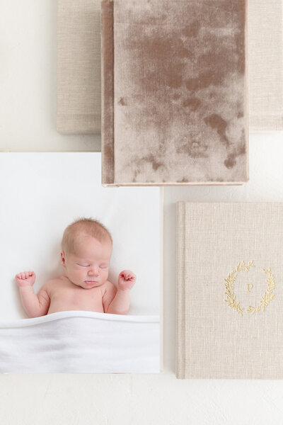 Portrait of a stack of linen and velvet albums with portraits taken by Northern Kentucky newborn photographer Missy Marshall