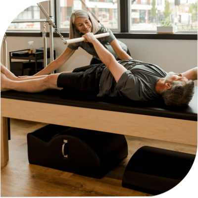 Roll down exercise on cadillac during a private lesson at Milwaukie Pilates