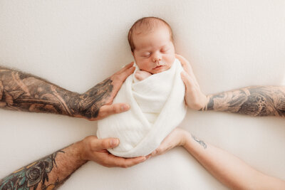 Newborn baby Cohen being held by his parents during his newborn photoshoot with newborn photographer michelle kelly