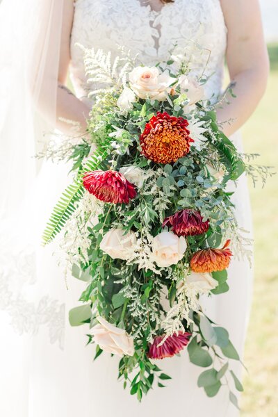 Bride holding a bright, colorful, and gorgeous floral bouquet on her wedding day, taken by local Nashville Wedding Photographers, Jennifer and Daniel Cooke.