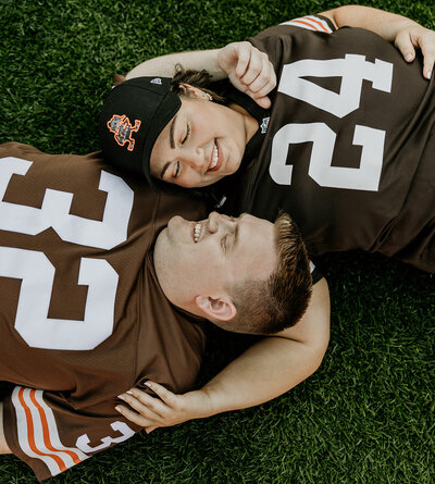 close up of husband and wife laying in the grass looking at each other for cute anniversary photos.