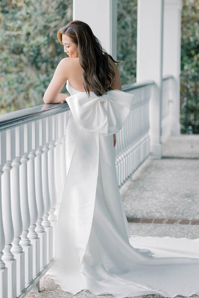 Charleston Wedding Photographer | Bride on wedding day looking down with big bow