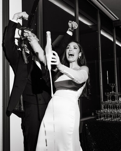 Couple cheering and holding a bottle of champagne with joy