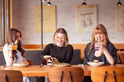 Patron of the Barley Merchant pulling a piece of pizza off her plate during a brand photoshoot