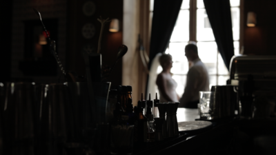 A blurred out image of a couple holding hands standing by large window