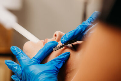 Woman receiving dermaplaning on her face