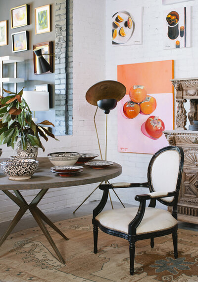 Interior shot of table and chair with bright modern art hanging on white walls