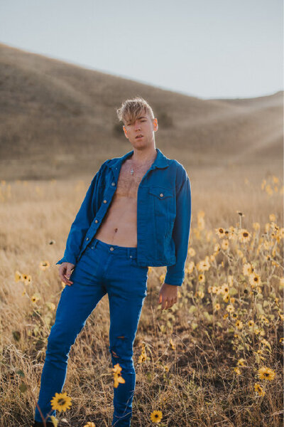 person in blue suit with sunflowers surrounding them