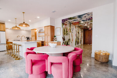 gourmet kitchen with gold accents, round dining table with pink chairs