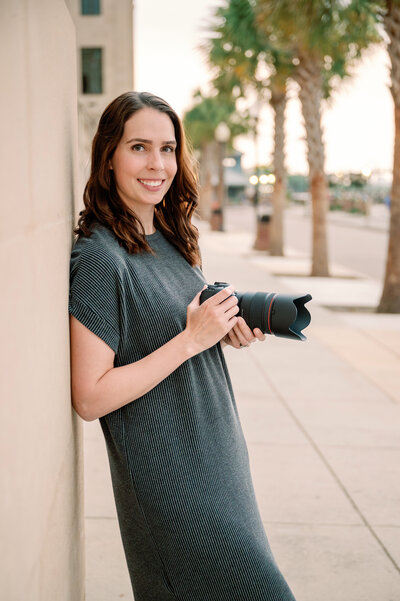 Portrait of D McHugh smiling with camera in hand,  wedding and portrait photographer in NC