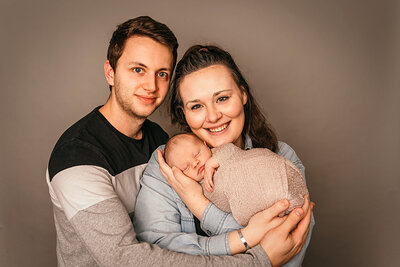 mum-and-dad-posing-with-newborn-baby-for-photoshoot