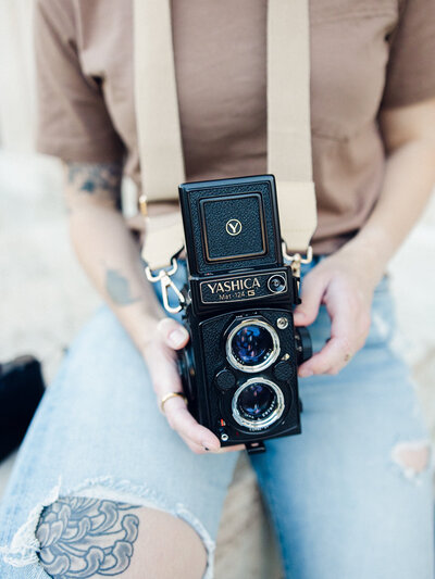 One of the top photographers in baltimore md holding camera and albums