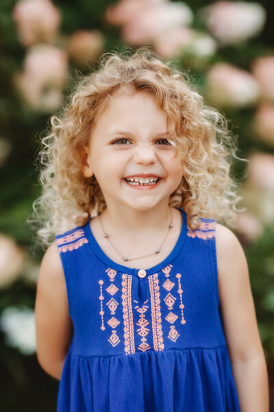 Little girl smiles at the camera during family photoshoot in Asheville, NC.