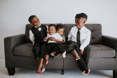 The Chocolate Babies, Theo, Uzi, Anaya, & Uriah Henry sitting on the couch.