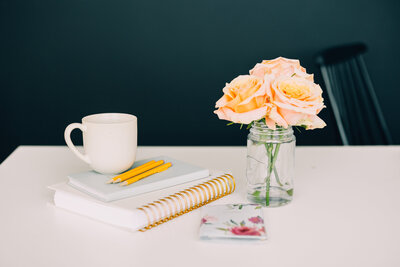 flowers and notebooks sitting on a desk