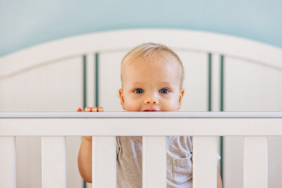 cute little boy in a crib during a family photography session.