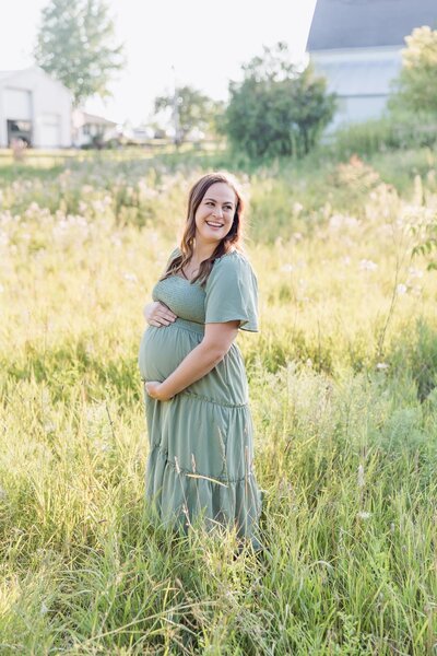 pregnant woman standing in a grassy field