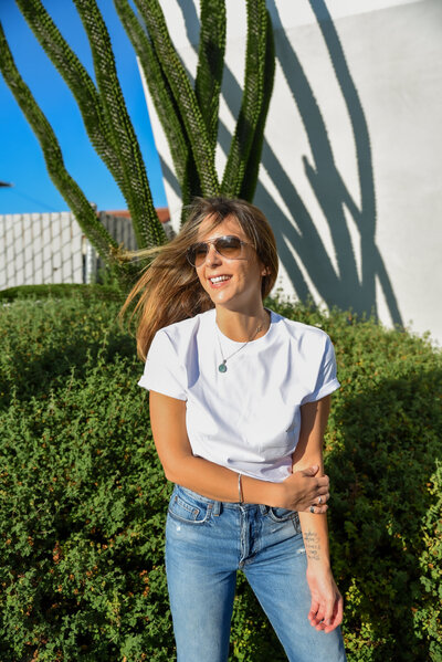 Portrait of a thin brunette woman in a white t-shirt and high waisted jeans