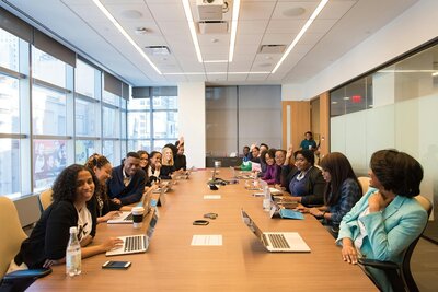 A group of diverse employees sit at a table in a training session