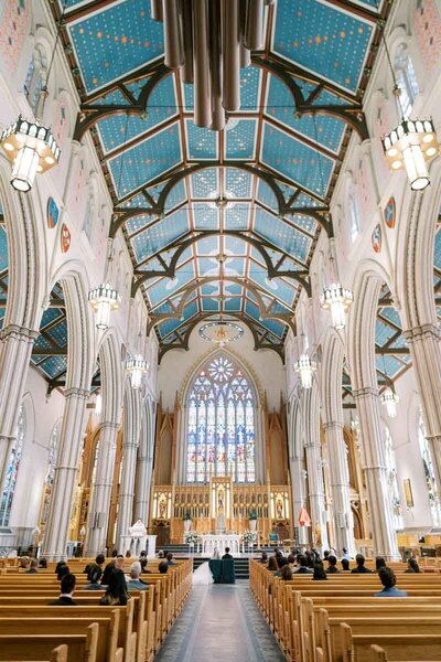 Grand cathedral wedding with stained glass and blue ceiling at St. Michael’s Basilica in downtown Toronto