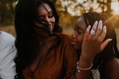 An african american mom holding her daughters cheek and softly smiling at her in Flower Mound, Texas.
