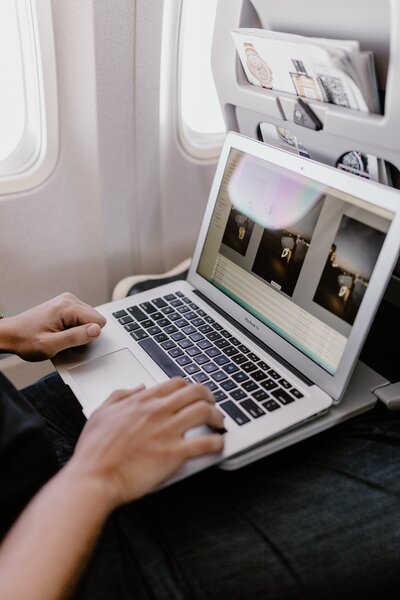 kaboompics_unrecognizable-man-with-notebook-sitting-inside-an-airplane-8008