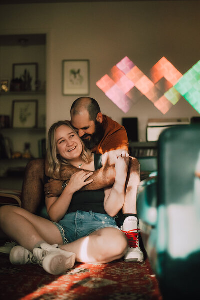 Man snuggles woman during Madison  in-home photo session
