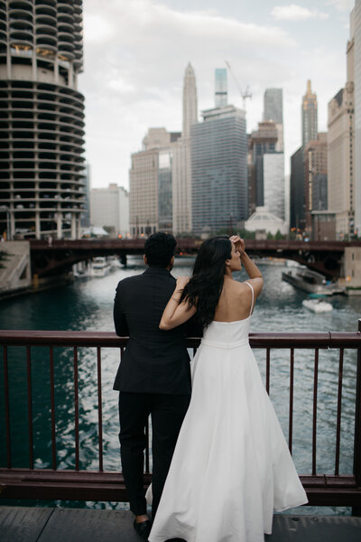 A Chicago elopement with couple facing the city skyline and overlooking the Riverwalk in Chicago