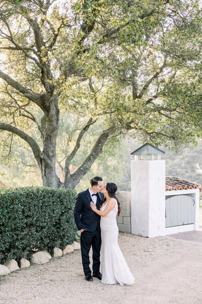 Bride and groom pose in the almond orchards at their Fresno wedding