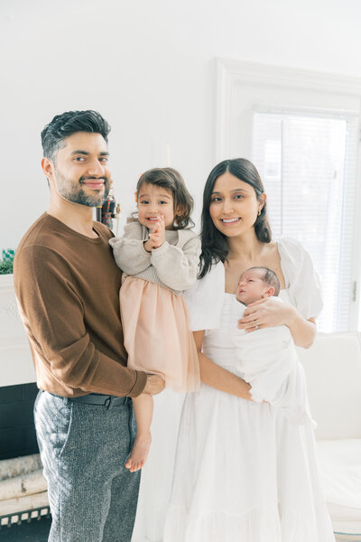 Dad with child on shoulders smiling at mom during family portrait session