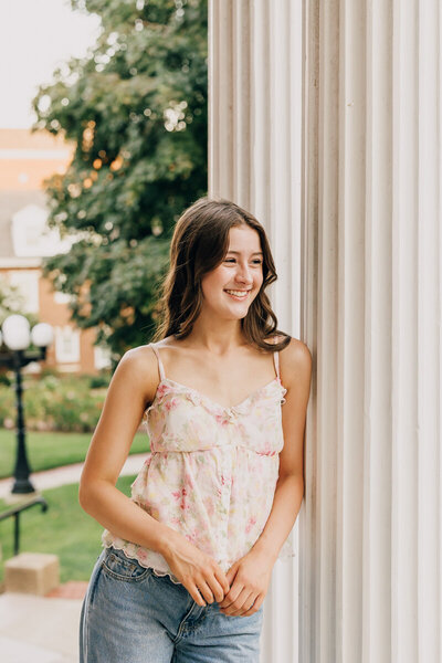 Girl leaning against a column at Belmont Mansion, looking into the distance.