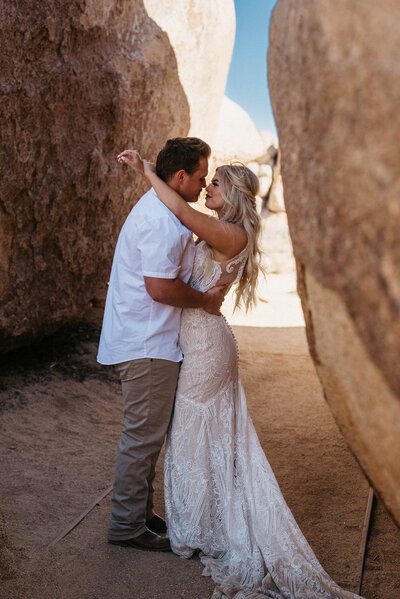 couple embraces between rocks