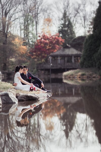 couple in front of a pavilion  by the water at their brookside gardens wedding