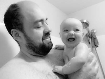 Hope's husband holding his baby who is giggling.