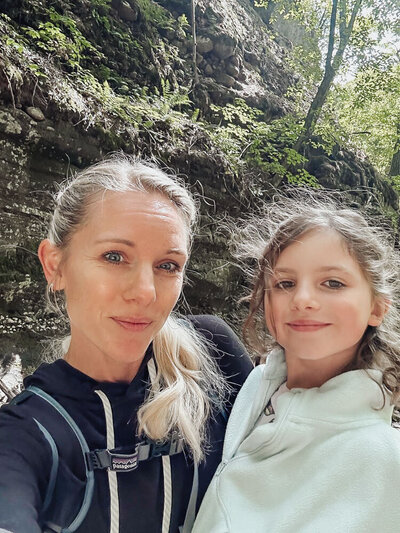 Caroline Weiss spending time with her daughter in nature, representing grounding, joy, and emotional balance.
