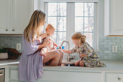 mom playing in sink with daughters