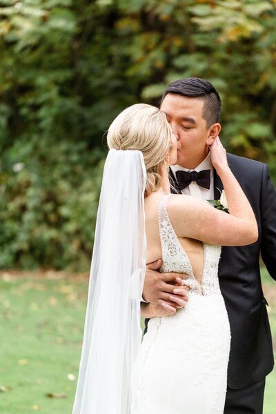 Groom pulls his wife in for a kiss at lionhead golf club in Oakville ontario