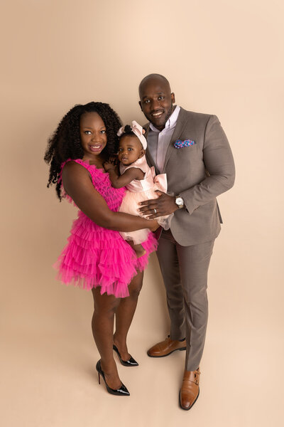 mom in hot pink dress posing for family photo byPhiladelphia Family Photographer