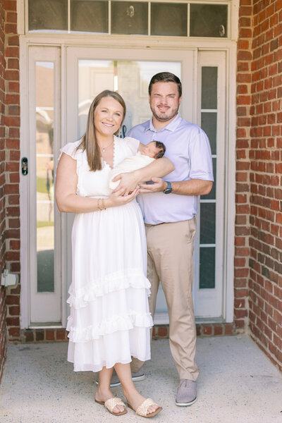 Newborn family photos in front of a home