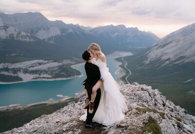 Couple sharing a kiss on top of a mountain