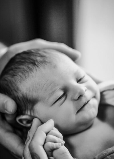 A delightful black and white photograph of a smiling baby, showcasing pure joy and innocence.