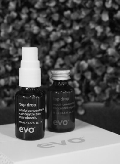 Two hair treatment bottles sitting on top of a box