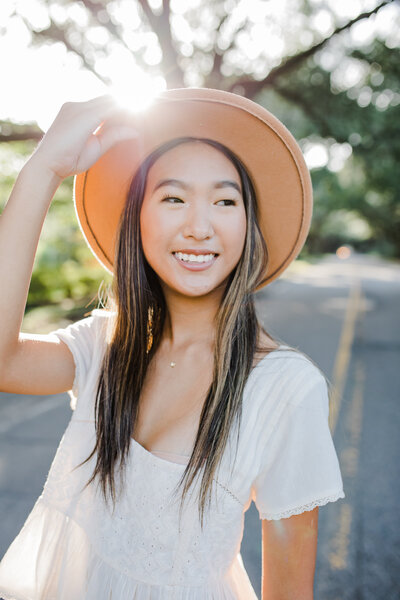 Downtown Aiken senior photos with girl holding her hat with augusta senior photographer