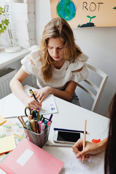 Teenage girl writing at table with pencil and paper | Rooted Within Santa Barbara educational evaluations for students