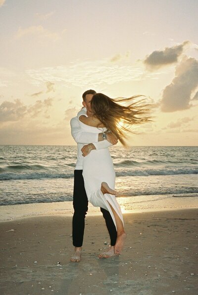 couple embracing and hugging after proposal on naples florida beach